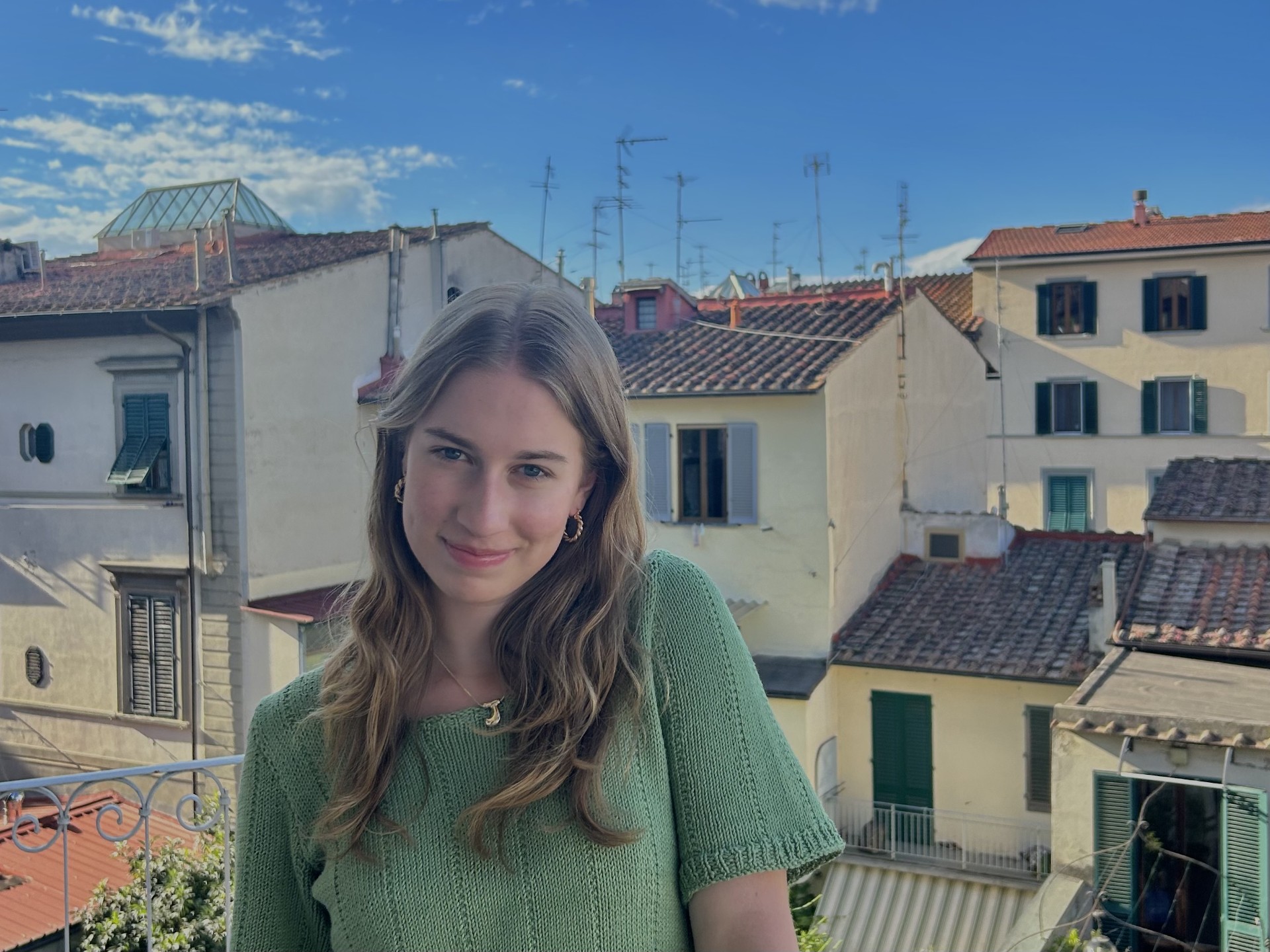 A student on a balcony overlooking a city.